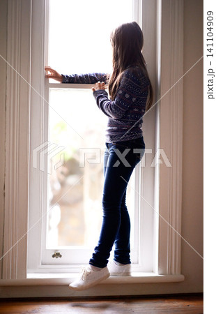 Thinking, window and back of child in home for relaxing, rest and calm on weekend. Youth, smile and young girl by glass for ideas, thoughtful and reflection for happiness, playing and childhood Thinking, window and back of child in home for relaxing, rest and calm on weekend. Youth, smile and young girl by glass for ideas, thoughtful and reflection for happiness, playing and childhood 141104909