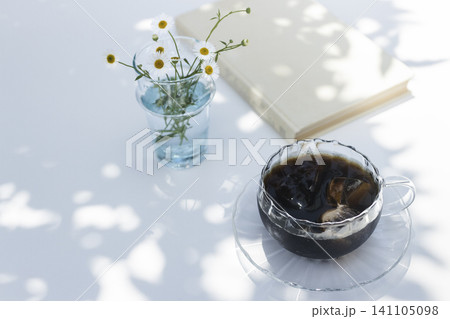 木漏れ日のテーブルに飾った小さな花とアイスコーヒー 夏の読書時間イメージ 木漏れ日のテーブルに飾った小さな花とアイスコーヒー 夏の読書時間イメージ 141105098