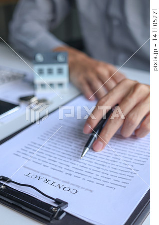 Close-up hand reading, signing contract for housing. Concept for real estate investment, home buying, selling, insurance, loan, lease, mortgage Close-up hand reading, signing contract for housing. Concept for real estate investment, home buying, selling, insurance, loan, lease, mortgage 141105271