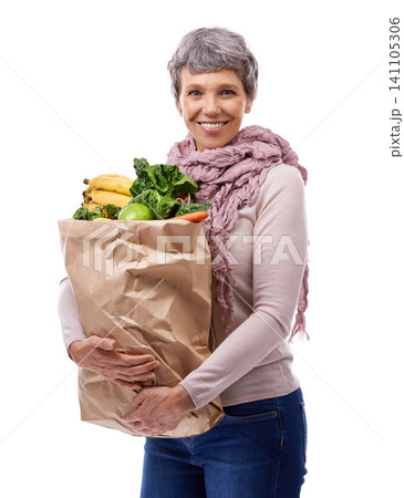 Woman, paper bag and portrait with vegetables for shopping, groceries and consumer for nutrition and fruits in studio. Mature lady, happy and hold produce for health and food on white backdrop Woman, paper bag and portrait with vegetables for shopping, groceries and consumer for nutrition and fruits in studio. Mature lady, happy and hold produce for health and food on white backdrop 141105306