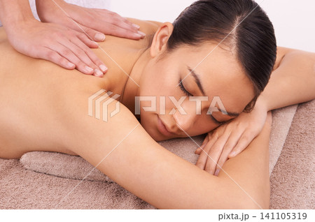 Hands, zen and woman with back massage at spa for wellness, self care and grooming treatment in studio. Skin, calm and female person with masseuse for body routine on table by white background. Hands, zen and woman with back massage at spa for wellness, self care and grooming treatment in studio. Skin, calm and female person with masseuse for body routine on table by white background. 141105319