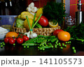 Fresh vegetables and fruit in woven basket with tomatoes peas cabbage peppers lemon and dill on black tablecloth close up 141105573