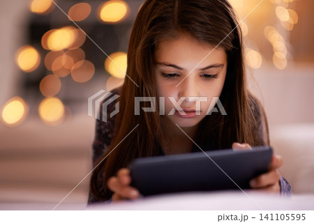 Home, night or kid with tablet for streaming, playing games or watching fun videos on movie website. Girl, house or young female child with technology to download online or social media app to relax Home, night or kid with tablet for streaming, playing games or watching fun videos on movie website. Girl, house or young female child with technology to download online or social media app to relax 141105595