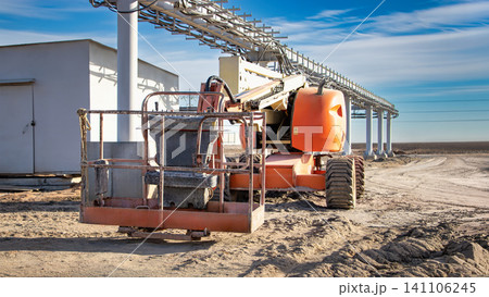 A self-propelled telescopic tower is positioned on a construction site. It is preparing for lifting tasks in clear weather with few clouds A self-propelled telescopic tower is positioned on a construction site. It is preparing for lifting tasks in clear weather with few clouds 141106245