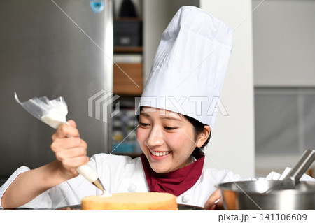 アジア人の女性パティシエがケーキを仕上げるイメージ アジア人の女性パティシエがケーキを仕上げるイメージ 141106609