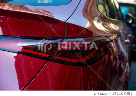 Car parked in a street of Prague showing red light reflection on the surface Car parked in a street of Prague showing red light reflection on the surface 141107498