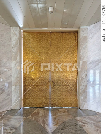 Massive golden gate of Al Jabbar with carvings. Massive golden gate of Al Jabbar with carvings. 141107769