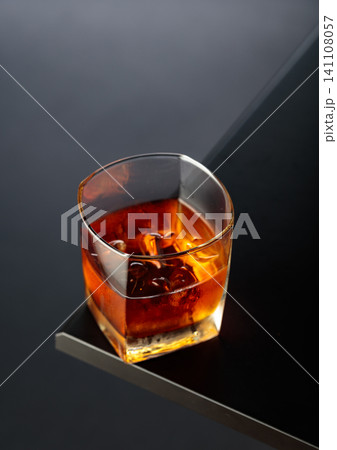 Whiskey with ice on a black table. Whiskey with ice on a black table. 141108057