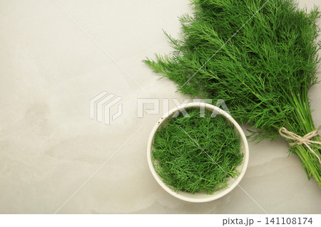 Bunch of green dill and dill on white bowl on light background. Space for text Bunch of green dill and dill on white bowl on light background. Space for text 141108174