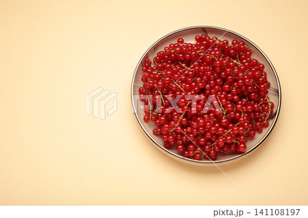 Red currants on plate on beige background. Fresh and vibrant food photography for healthy eating. Red currants on plate on beige background. Fresh and vibrant food photography for healthy eating. 141108197