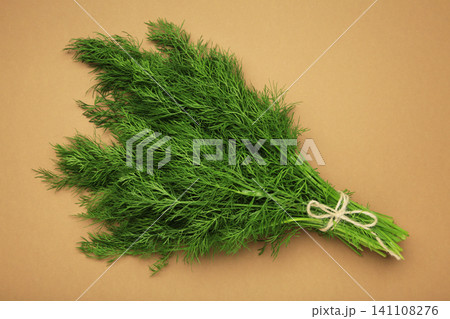 Bunch of green dill on brown background. Bunch of green dill on brown background. 141108276