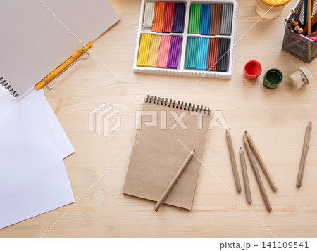 Creative workspace with pencils paints and sketchbook top view 141109541