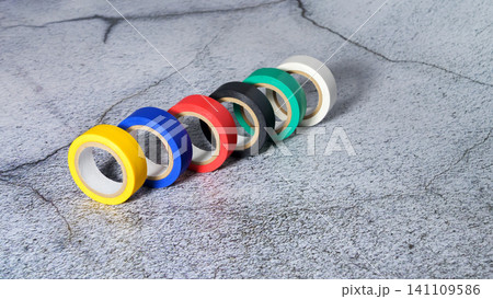 colorful electrical tape stands in a row diagonally on a gray background colorful electrical tape stands in a row diagonally on a gray background 141109586