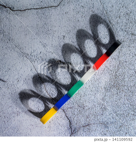 multicolored rolls of electrical tape lie connected in a tight line on a gray concrete surface multicolored rolls of electrical tape lie connected in a tight line on a gray concrete surface 141109592