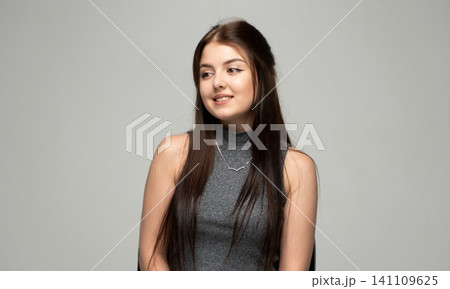 Young brunette woman looking away, smiling subtly and expressing happiness. Studio shot with copy space Young brunette woman looking away, smiling subtly and expressing happiness. Studio shot with copy space 141109625