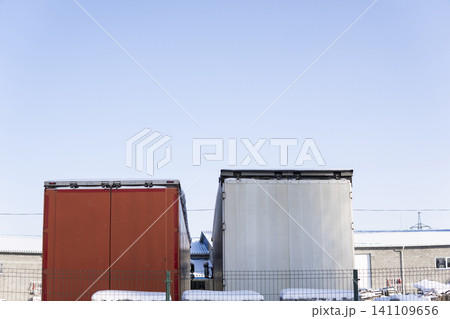 Two freight trailers parked in a row, showing logistics, goods transportation, and industrial shipping in winter Two freight trailers parked in a row, showing logistics, goods transportation, and industrial shipping in winter 141109656