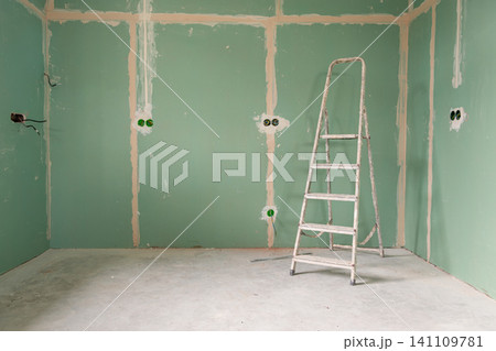 Green drywall room under construction with aluminum ladder Green drywall room under construction with aluminum ladder 141109781