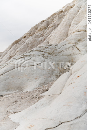 White rock formations with textured surface and cloudy sky backdrop 141110272