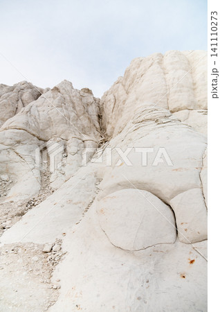 White rock formations with textured surface against a cloudy sky 141110273