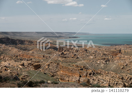 Rocky coastal landscape with turquoise water and distant cliffs Rocky coastal landscape with turquoise water and distant cliffs 141110279