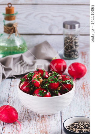 Delicious appetizer of smashed pickled radishes with herbs in a bowl on the table vertical view Delicious appetizer of smashed pickled radishes with herbs in a bowl on the table vertical view 141110865