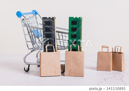 Computer memory modules (RAM) in shopping bags near a shopping cart on a table 141110891