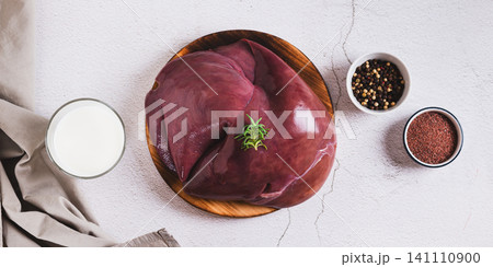 Fresh beef liver on a cutting board on the table top view web banner Fresh beef liver on a cutting board on the table top view web banner 141110900