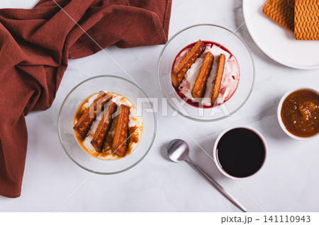 Japanese cheesecake made with cream cheese, cookies, and berry jam in cups on a table top view 141110943