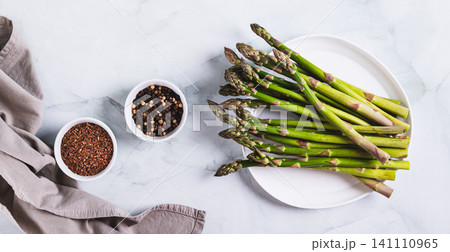 Organic vegetable fresh asparagus spears on a plate on the table top view web banner 141110965