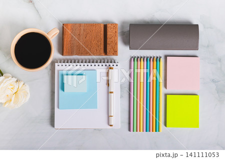 A notebook, pen, cup of coffee and stationery on a desk top view 141111053