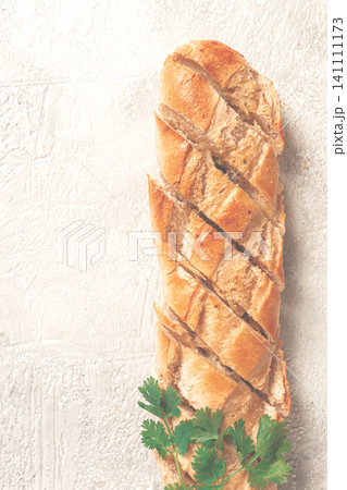 garlic bread,baguette with garlic butter and herbs, on a light table, top view, garlic bread,baguette with garlic butter and herbs, on a light table, top view, 141111173