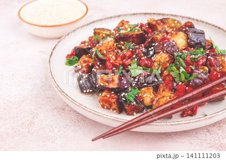 fried eggplant, Chinese style, in sweet and sour sauce, with pepper and sesame seeds. on a white plate, fried eggplant, Chinese style, in sweet and sour sauce, with pepper and sesame seeds. on a white plate, 141111203