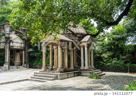 Ancient stone pavilion surrounded by lush greenery 141112077