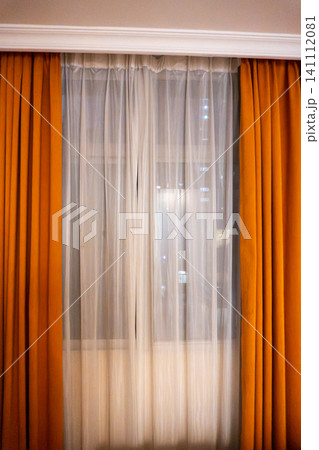 Window with orange curtains in cozy room setting 141112081