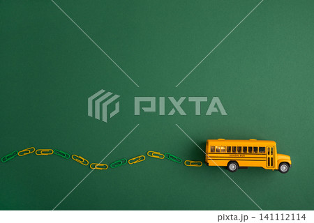 Yellow school bus driving along paperclip road Yellow school bus driving along paperclip road 141112114