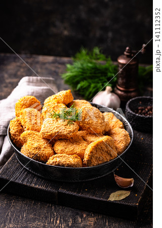 Raw uncooked frozen chicken nuggets Raw uncooked frozen chicken nuggets 141112352