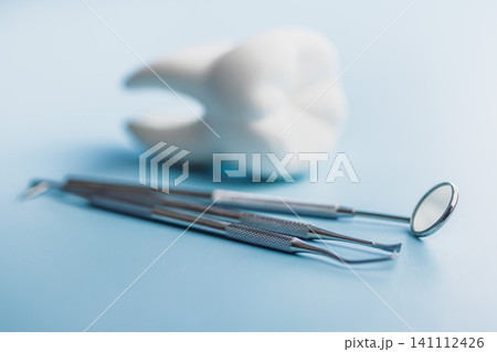 Dental Tools and Tooth Model on Blue Background for Oral Care and Dental Clinic Use Dental Tools and Tooth Model on Blue Background for Oral Care and Dental Clinic Use 141112426