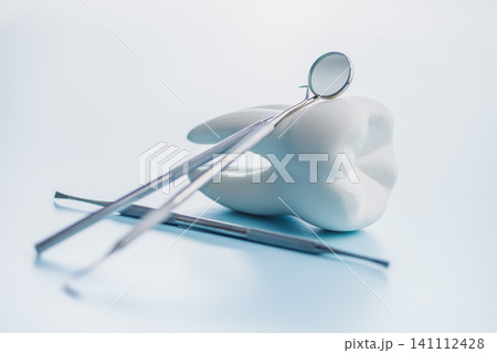 Dental Tools and Tooth Model on Blue Background for Oral Care and Dental Clinic Use 141112428