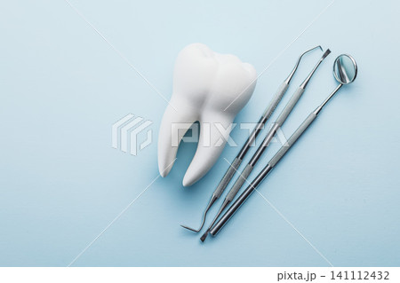 Dental Tools and Tooth Model on Blue Background for Oral Care and Dental Clinic Use Dental Tools and Tooth Model on Blue Background for Oral Care and Dental Clinic Use 141112432