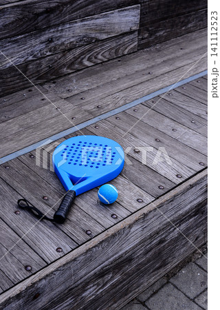 A padel racket and ball. on blue court A padel racket and ball. on blue court 141112523