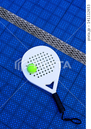 A padel racket and ball. on blue court A padel racket and ball. on blue court 141112653
