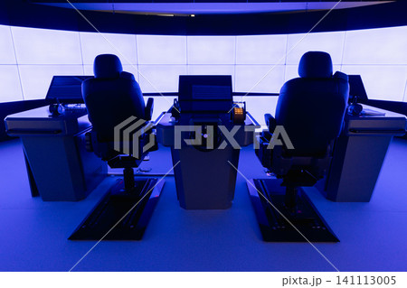 A modern ship bridge simulator control room featuring two captain chairs, central helm A modern ship bridge simulator control room featuring two captain chairs, central helm 141113005