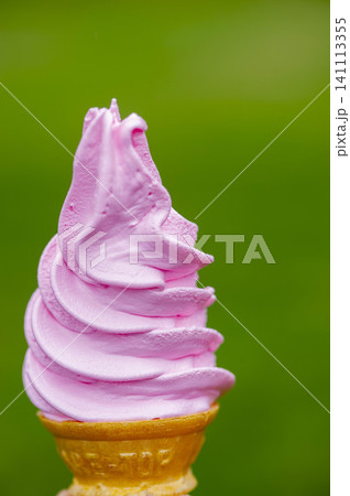 緑の背景にそびえ立つ苺味ソフトクリーム、ピンク色の美しいサーティングス 緑の背景にそびえ立つ苺味ソフトクリーム、ピンク色の美しいサーティングス 141113355