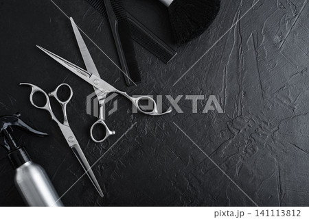 Professional hairdresser tools on a black textured concrete background. Professional hairdresser tools on a black textured concrete background. 141113812