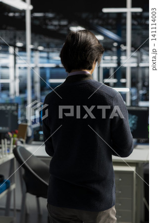 System administrator uses a computer in a data center to deploy software updates, configure hardware, and support reliable operations. 141114003