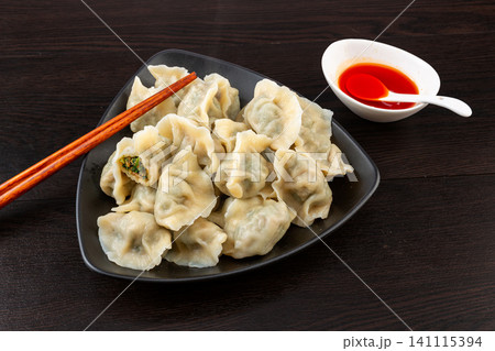 Steamed Chinese pork and shepherd's purse dumplings Jiaozi on traditional blue pattern plate Steamed Chinese pork and shepherd's purse dumplings Jiaozi on traditional blue pattern plate 141115394