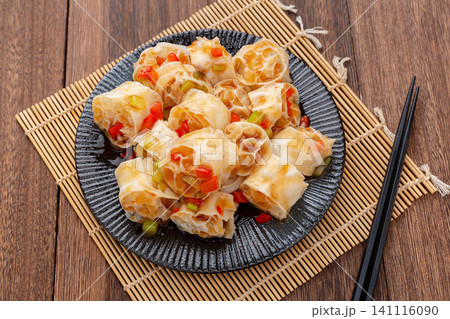 refreshing cold wheat gluten salad with garlic and chili sauce on a dark wooden table 141116090