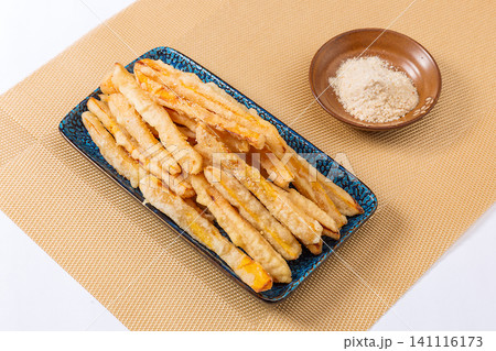 fried sweet potato sticks served with plum powder dipping sauce on plate. 141116173