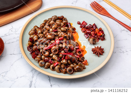 a plate of stir-fried river snails with dried chilies and wooden spoon, rustic style Chinese food background. a plate of stir-fried river snails with dried chilies and wooden spoon, rustic style Chinese food background. 141116252