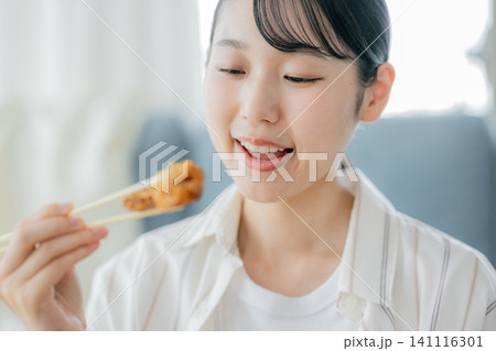 唐揚げを食べる若い女性 141116301